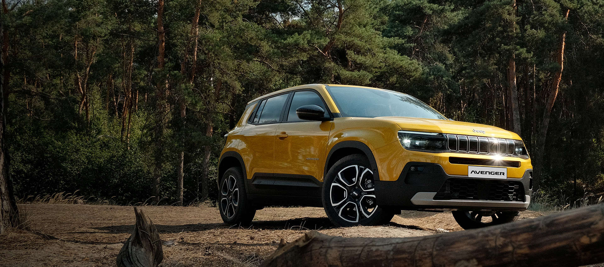 Jeep Avenger e-Hybrid на галявині у сосновому лісі